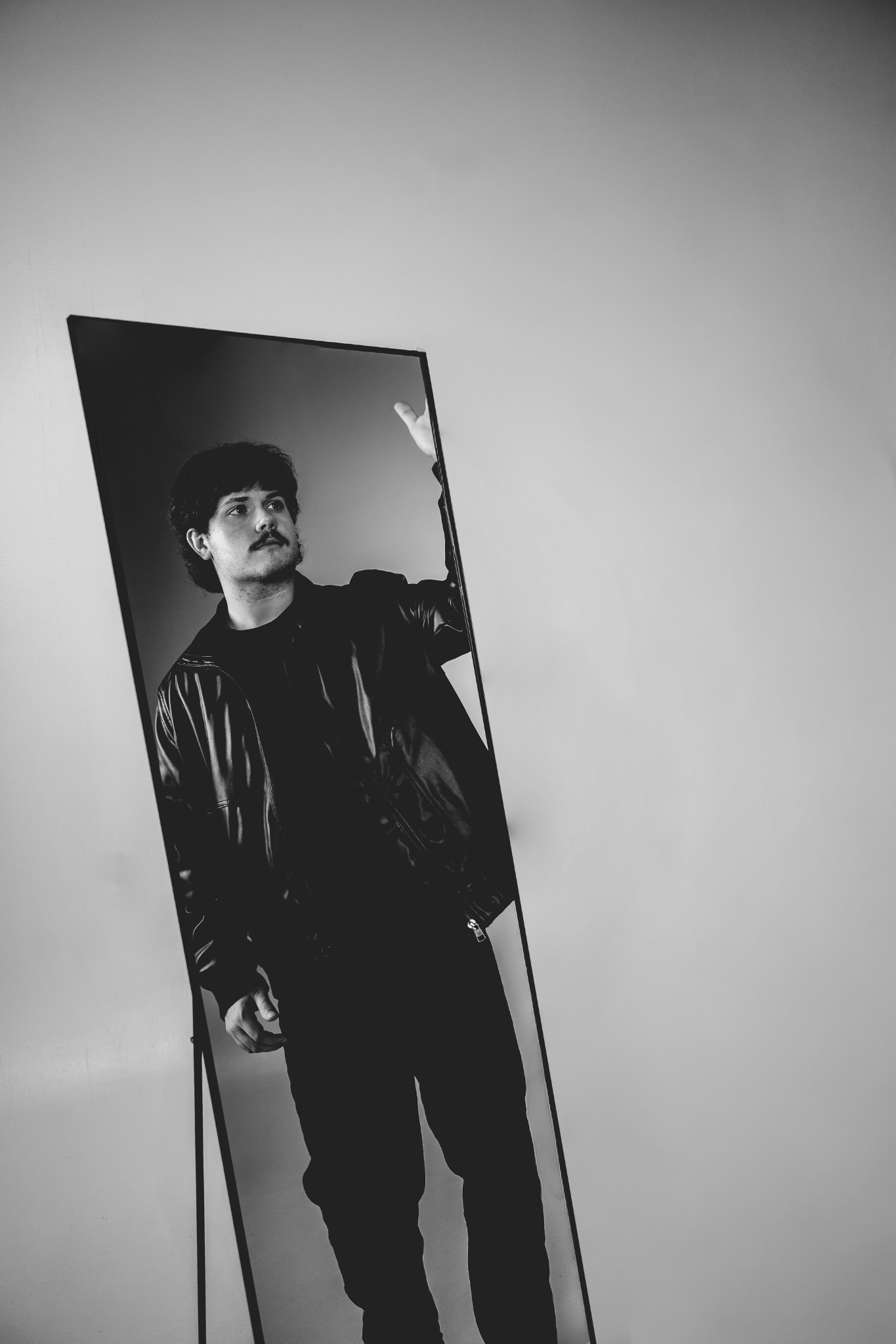 Tye Cristo reflected in a tall angled mirror